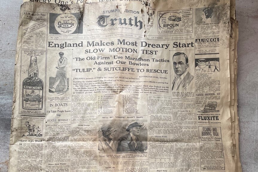 A faded 1930 newspaper with information about a cricket Ashes Test underway and old photos.