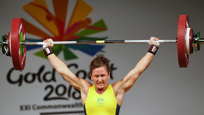 Tia-Clair Toomey holds a barbell over her head.