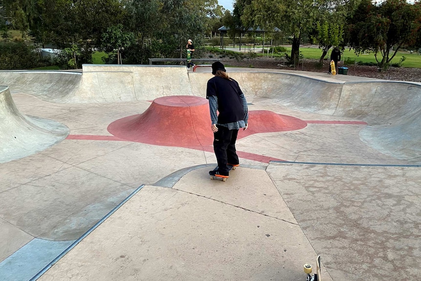 A skater prepares to drop into a skate bowl