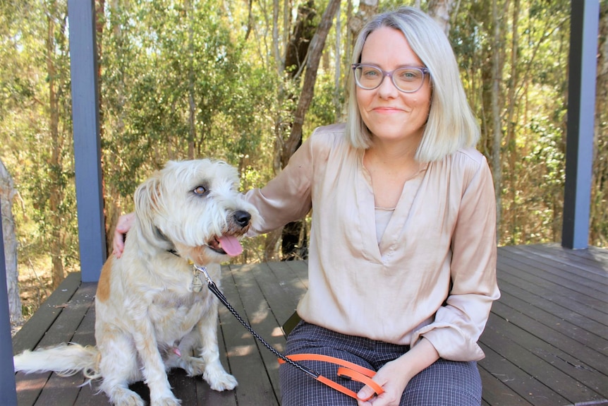 A lady sitting next to her dog