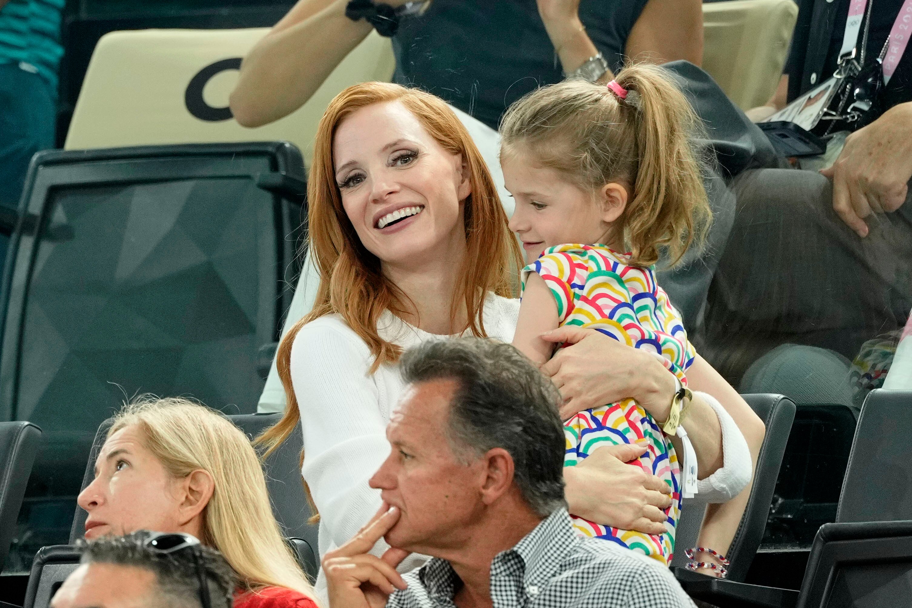 Jessica Chastain attends women’s qualification with her daughter holding her and smiling at the camera
