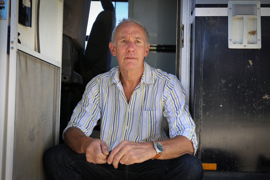 Philip Duncan sits on the step of his bus