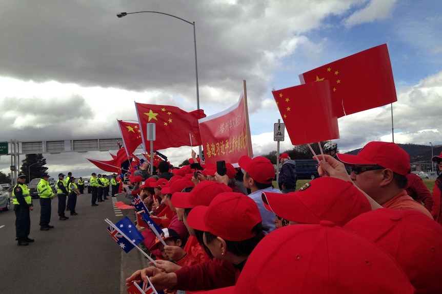 Supporters wave Chinese flags for President Xi Jinping in Hobart