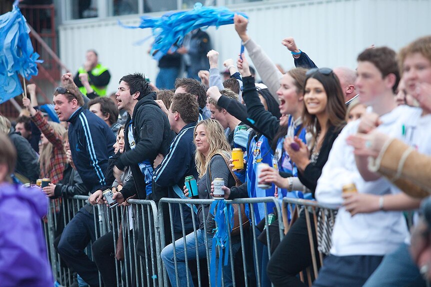 Football fans cheering at a local football grand final in Tasmania