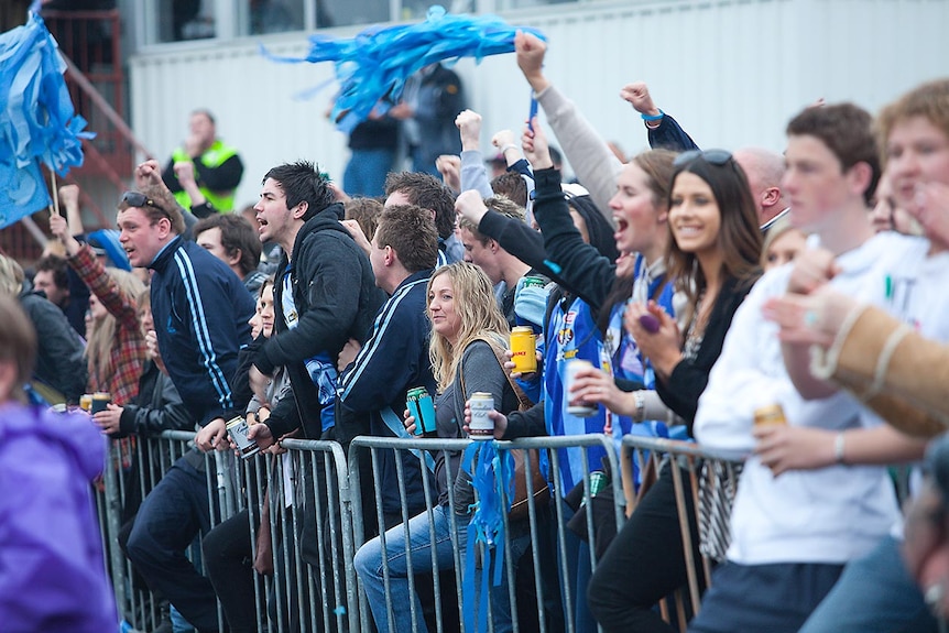 Football fans cheering at a local football grand final in Tasmania