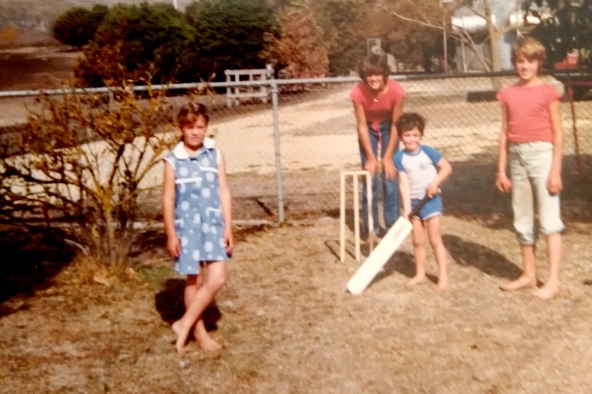 A family playing backyard cricket.