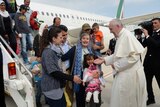 Pope Francis welcomes a groups of refugees disembarking from a plane in Rome.