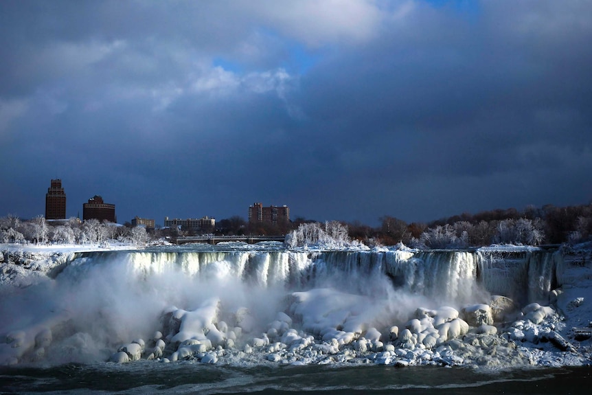 Water flows over the American Falls as ice forms in this view from the Canadian side in Niagara Falls.