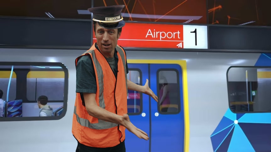 Picture of Sammy J in front of a train, 'airport' sign in background
