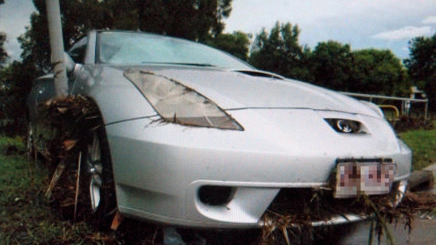 Debris covers a car damaged by floodwaters in Darra.