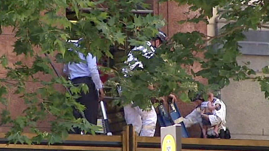 A baby is evacuated from a building in Sydney's CBD.