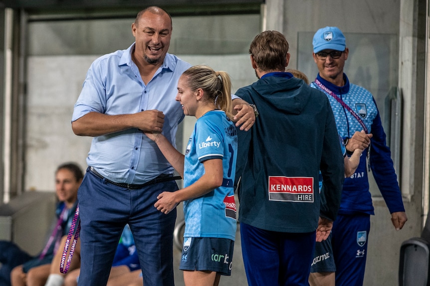 Sydney FC's A-League Women coach shakes hands with one of his players.