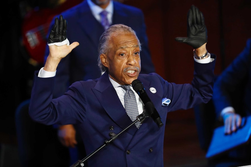 Al Sharpton raises his hands as he speaks at the lecturn at a memorial for George Floyd