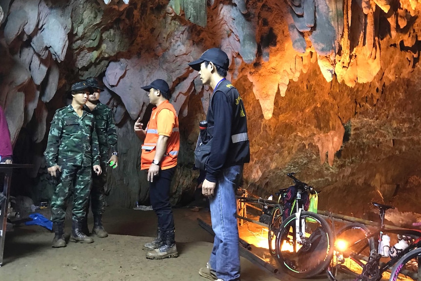 Members of the emergency rescue team talk in the staging area as they continue the search for a young football team