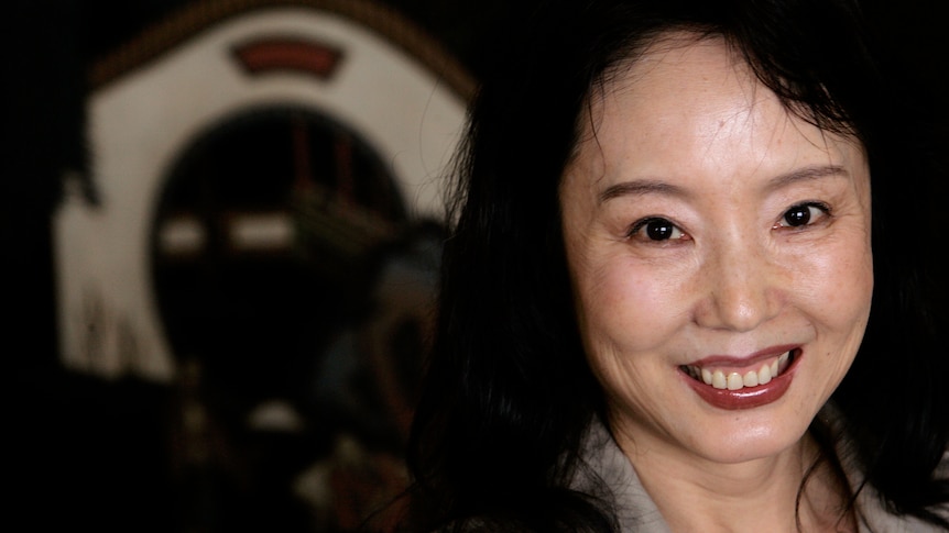 A profile photo of author Yan Geling who looks near the camera and smiles.
