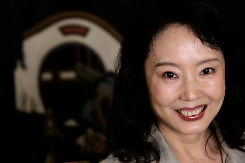 A profile photo of author Yan Geling who looks near the camera and smiles.