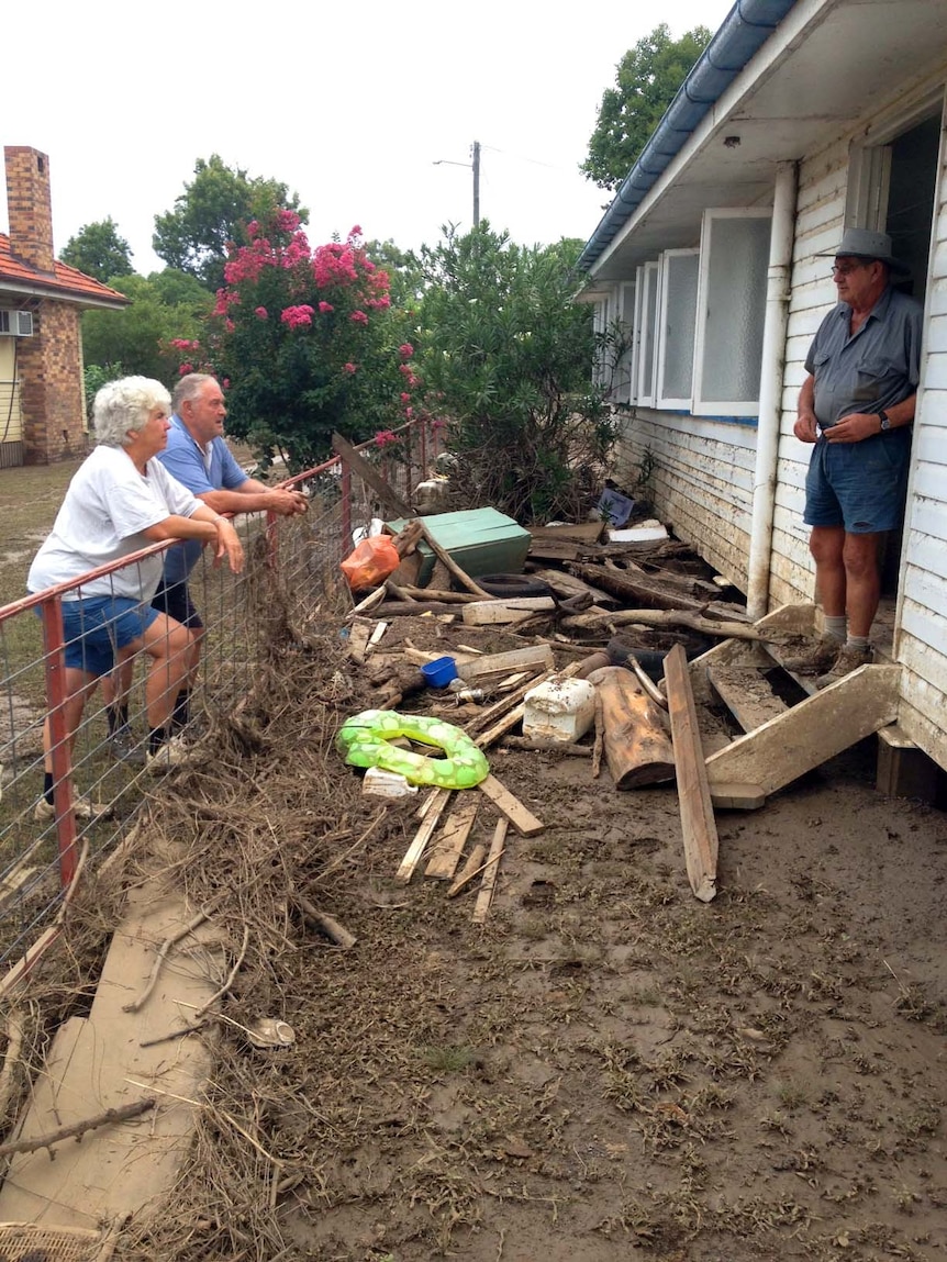 Mitchell residents survey flood damage to a house on February 7.