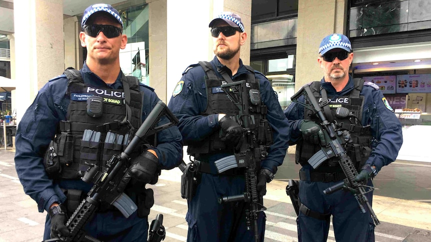 Three special police holding long-arm guns.
