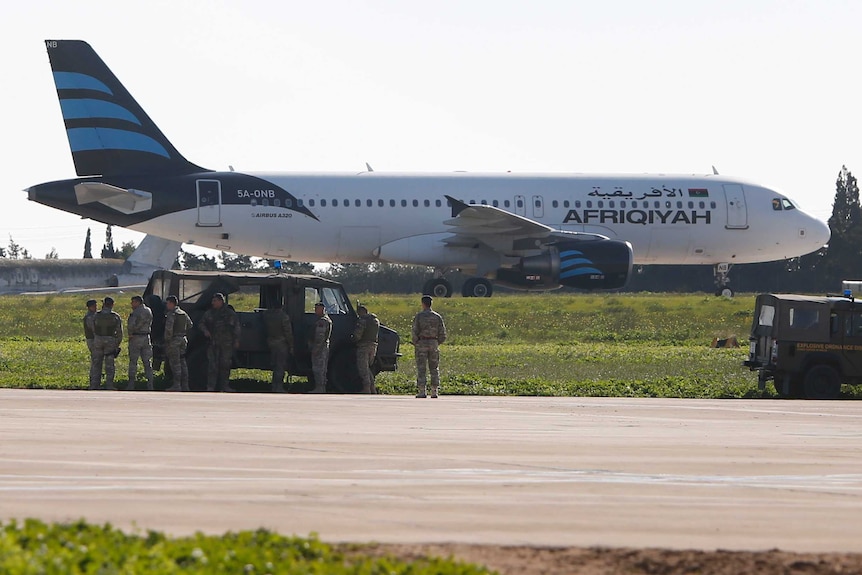 Maltese troops survey a hijacked Libyan Afriqiyah Airways Airbus A320.