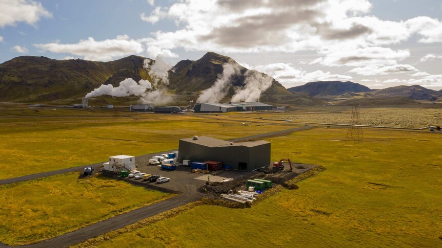 A steaming production plant against a green Icelandic countryside.