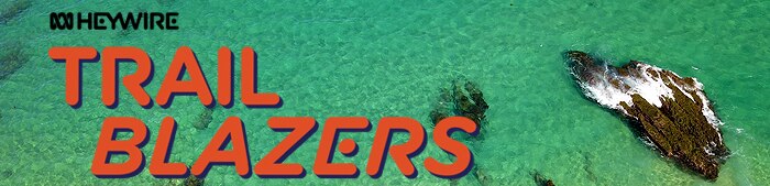 The word trailblazers is seen over a background of aqua sea with three rocks in the image. The word Heywire is seen at the top.