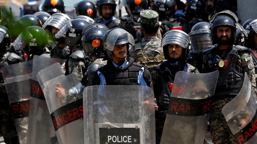Pakistani police in riot gear stand outside the high court.