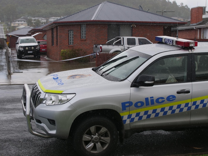 Tasmania Police vehicles at a crime scene.