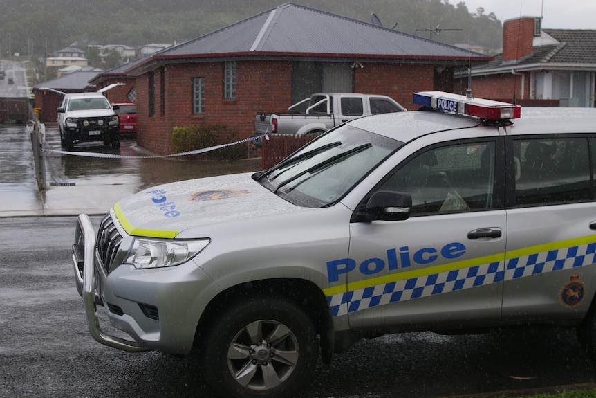 Tasmania Police vehicles at a crime scene.