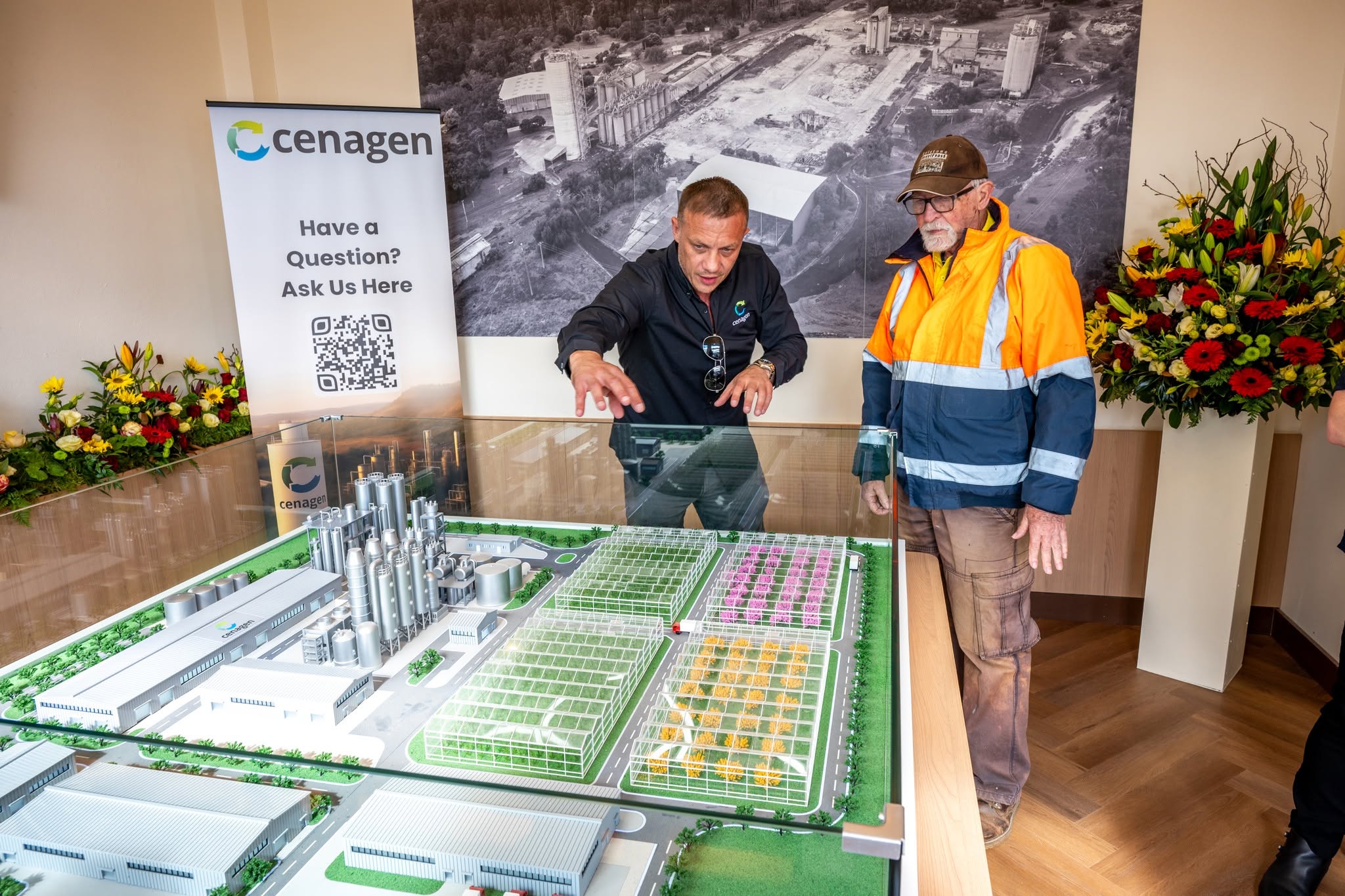 Two men standing next to a model building