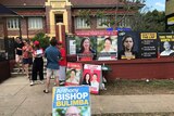 A polling station with many colourful candidate signs out the front.