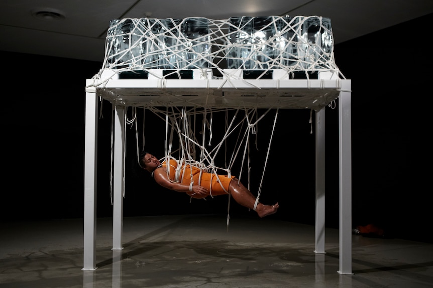 The artist Latai Taumoepeau suspended under melting ice