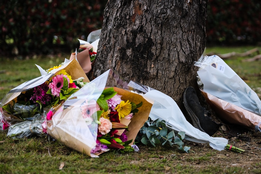 Close-up of flowers at base of tree at the scene of the fatal Buxton crash on September 7, 2022