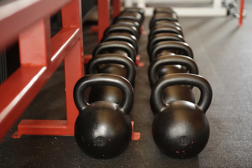 Kettle bells on the floor of a gym.