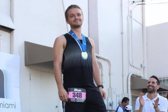 Matthew Dawson-Clarke wears a gold medal after winning a long distance race.