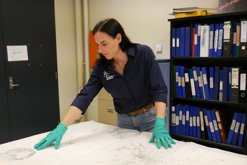 A woman looks at a map on a table