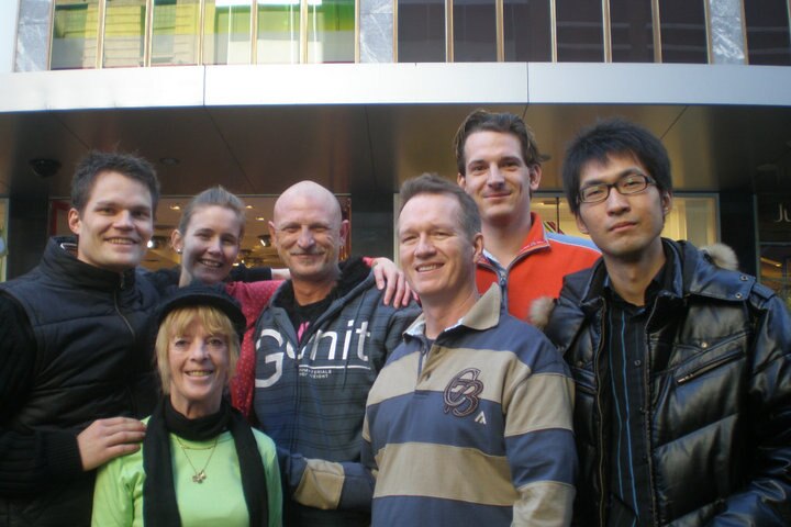 Group of people standing in front a building.