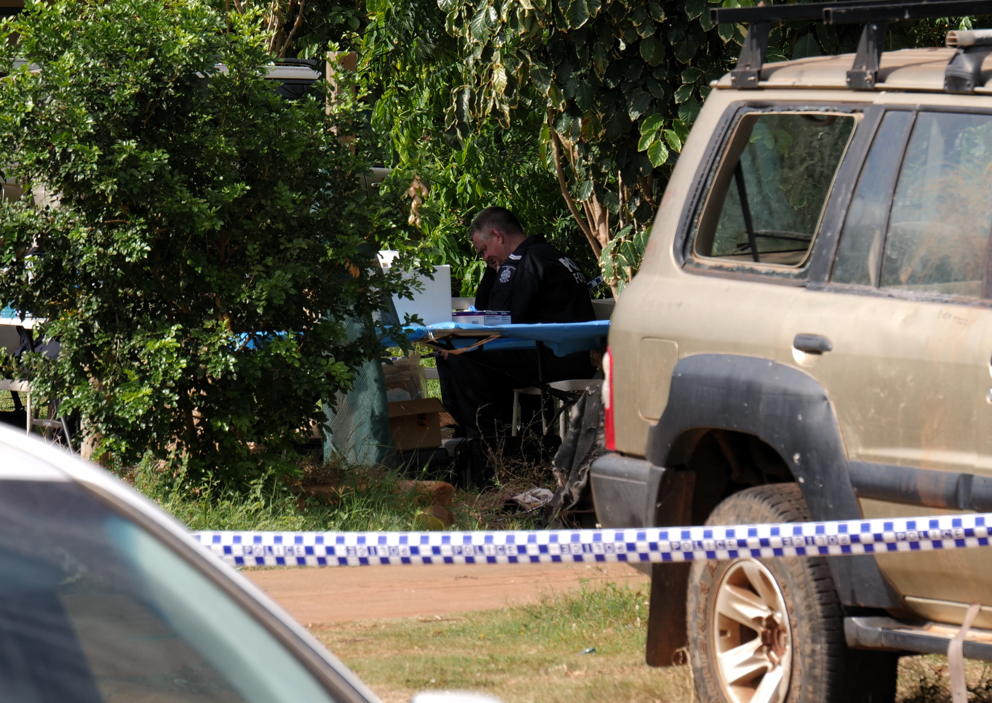 Police officers at a table behind tape