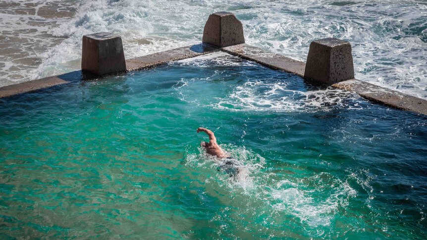 A closer aerial view of Kenton Webb swimming freestyle in the Coogee ocean pool