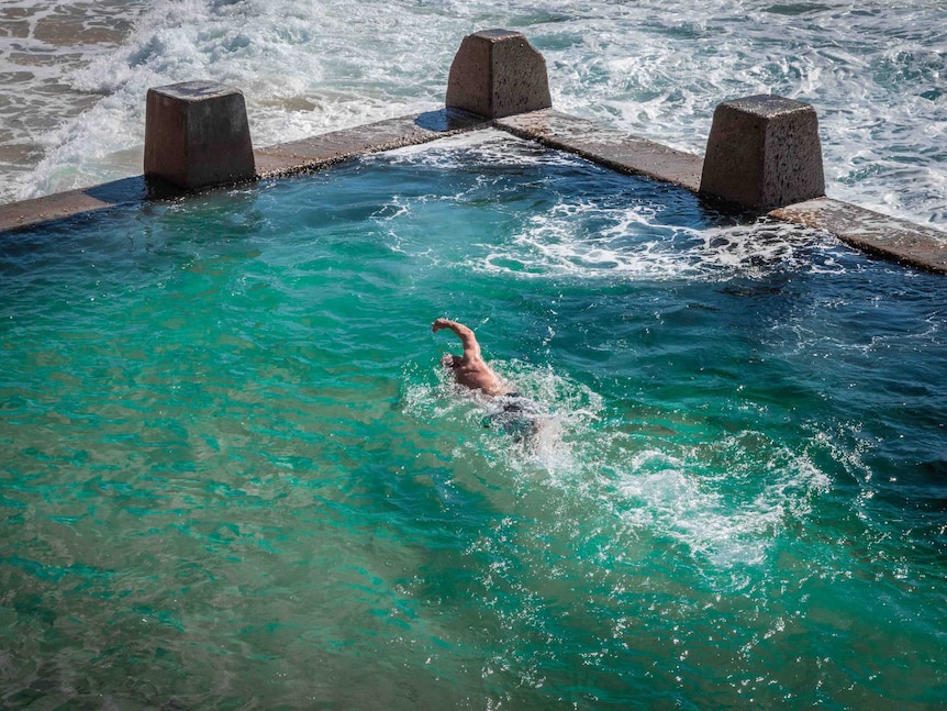 A closer aerial view of Kenton Webb swimming freestyle in the Coogee ocean pool