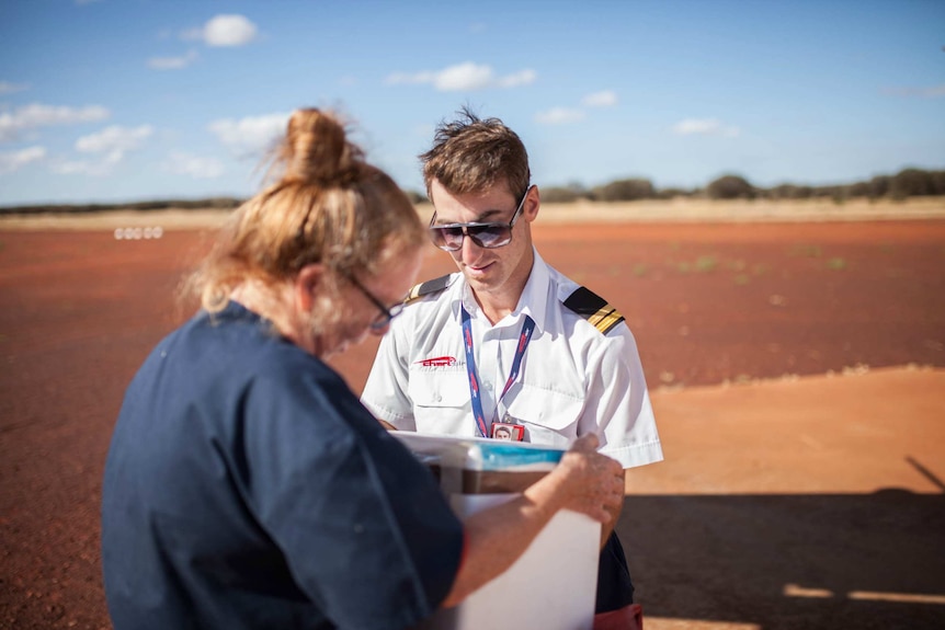 Chartair pilot Harvey Salameh helps unload mail in Cosmo Newbery, WA.