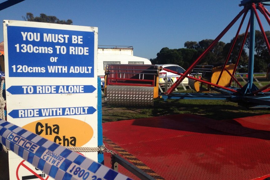 A carnival sign that says 'you must be 130cm to ride' stands in front of the Cha Cha ride at Rye.