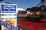 A carnival sign says 'you must be 130m to ride' and stands in front of the Cha Cha ride at Rye.