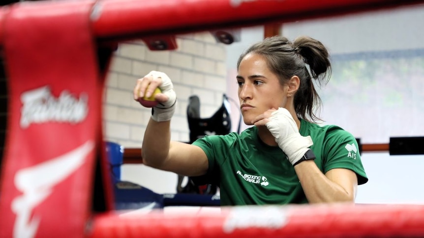 A woman practises in a boxing ring.
