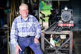 Rail enthusiast Neil MacKenzie, at his Brisbane home with one of his miniature steam locomotives
