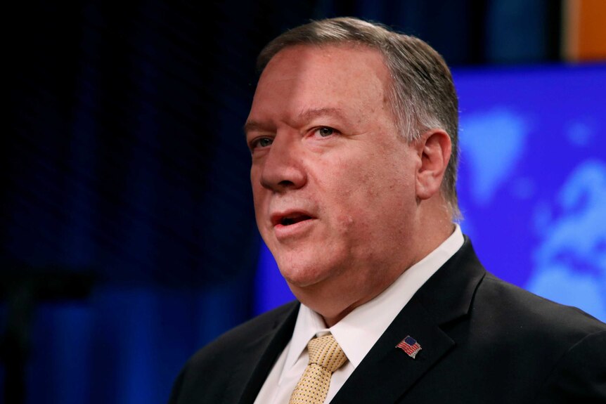 A close up of Mike Pompeo talking in front of a blue screen.