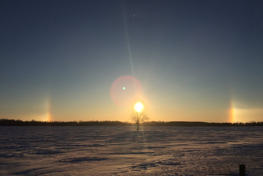 Sun dogs appear in the sky with crystals at the top outside of St Mary's in Ontario, Canada.