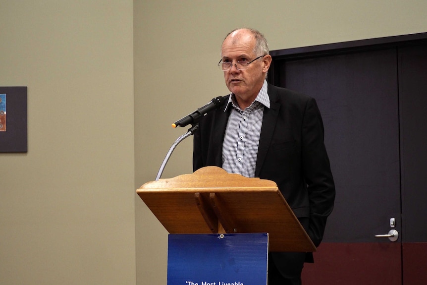 ACCC Deputy Chair Mick Keogh at a microphone stand.