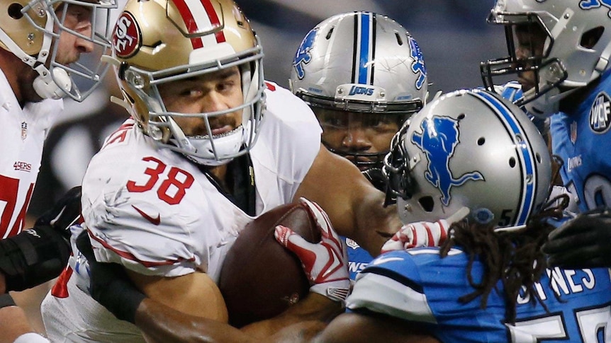 Tight photo of Jarryd Hayne of the San Francisco 49ers trying to break a tackle by Josh Bynes of the Detroit Lions.