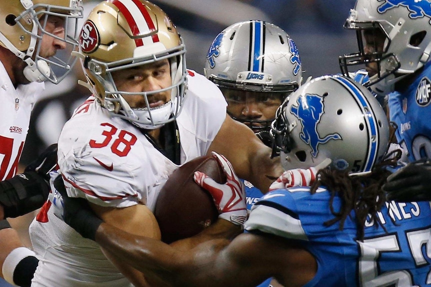 Tight photo of Jarryd Hayne of the San Francisco 49ers trying to break a tackle by Josh Bynes of the Detroit Lions.