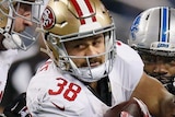 Tight photo of Jarryd Hayne of the San Francisco 49ers trying to break a tackle by Josh Bynes of the Detroit Lions.